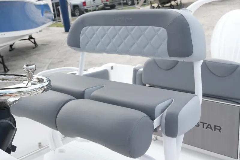 Slide: The Image of 2025 NauticStar 222 Offshore boat interior with gray cushioned seating and steering wheel. - 11