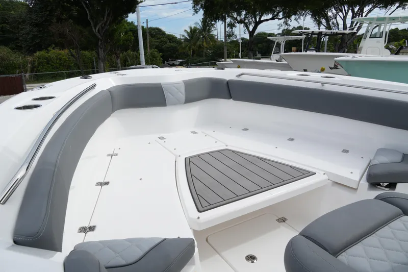 Slide: The Image of 2025 NauticStar 222 Offshore boat interior with gray seating and deck, surrounded by trees. - 6