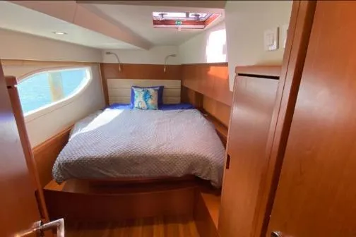 Slide: The Image of Cozy bedroom in 2014 Aquila 48 PC yacht with natural light and wooden finishes. - 13