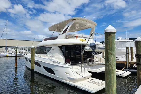 Slide: The Image of 2014 Aquila 48 PC yacht docked at marina under blue sky. - 2