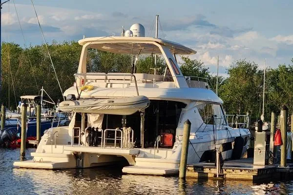 Slide: The Image of Aquila 48 PC 2014 yacht docked at marina, surrounded by trees and calm water. - 24