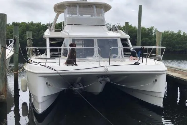 Slide: The Image of 2014 Aquila 48 PC catamaran docked, featuring spacious deck and modern design. - 26