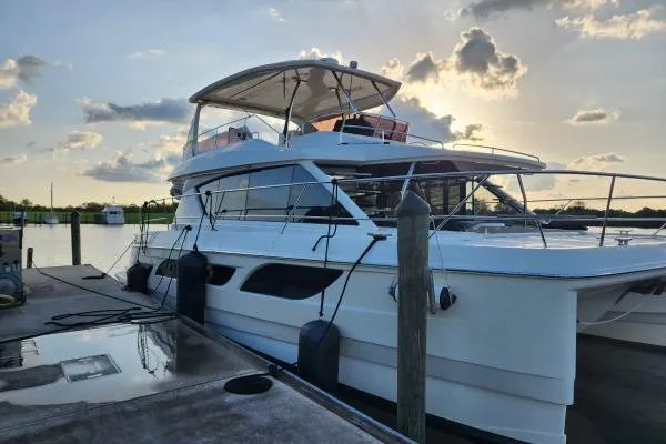 Slide: The Image of Aquila 48 PC 2014 yacht docked at sunset with scenic sky backdrop. - 3
