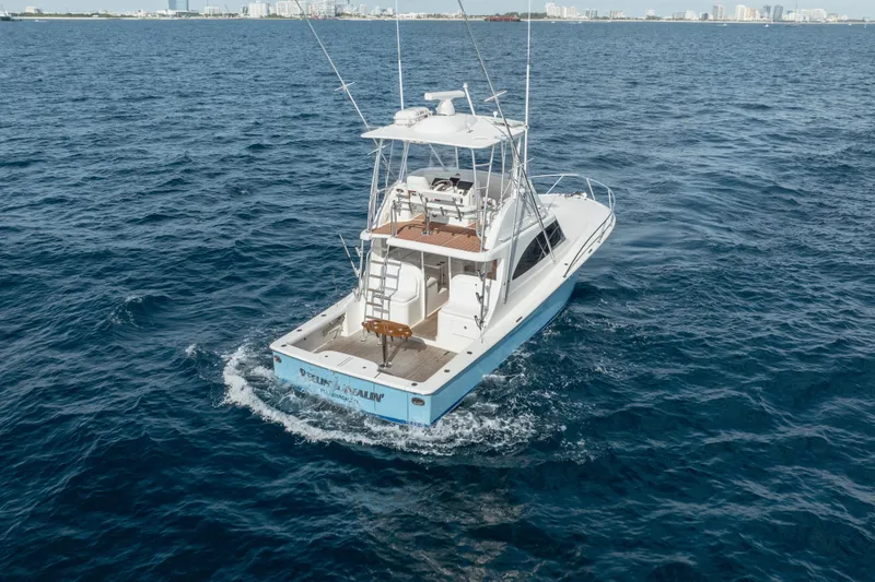Slide: The Image of 2018 Viking 37 Billfish yacht cruising on open ocean near city skyline. - 37
