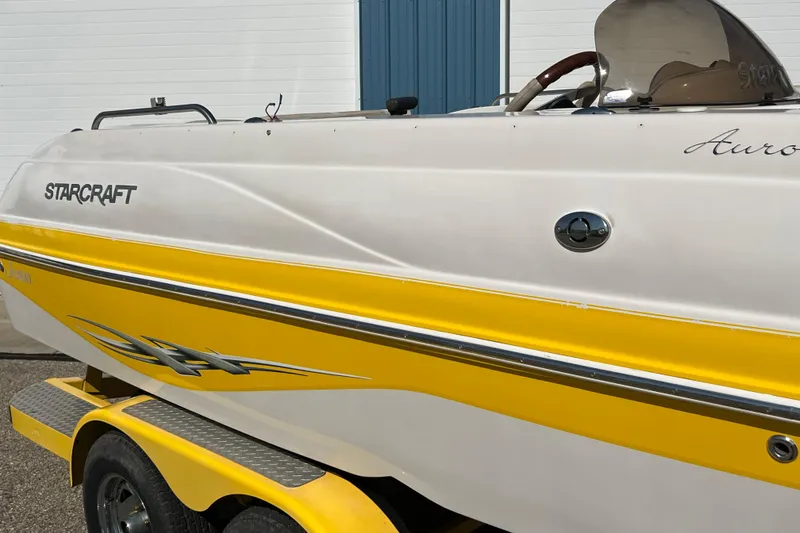 Slide: The Image of 2004 Starcraft Aurora 2000 I/O boat with yellow and white exterior on trailer. - 10
