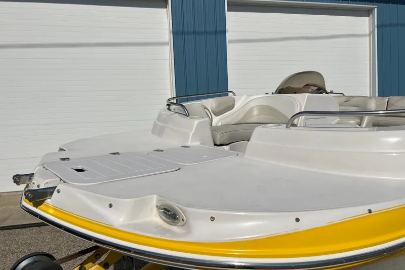 Slide: The Image of 2004 Starcraft Aurora 2000 I/O boat with yellow trim, parked near blue garage doors. - 16
