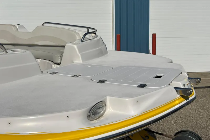 Slide: The Image of 2004 Starcraft Aurora 2000 I/O boat, white and yellow, docked near a blue building. - 8