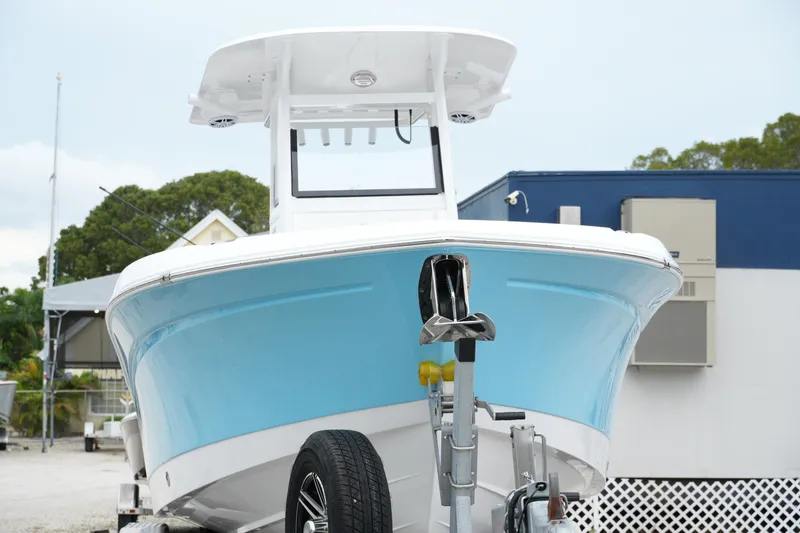 Slide: The Image of 2025 NauticStar 242 Offshore boat on trailer, front view, light blue hull. - 3