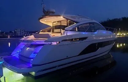 Slide: The Image of Fairline 45/43 Targa 2020 yacht illuminated at night, docked in a serene marina. - 15