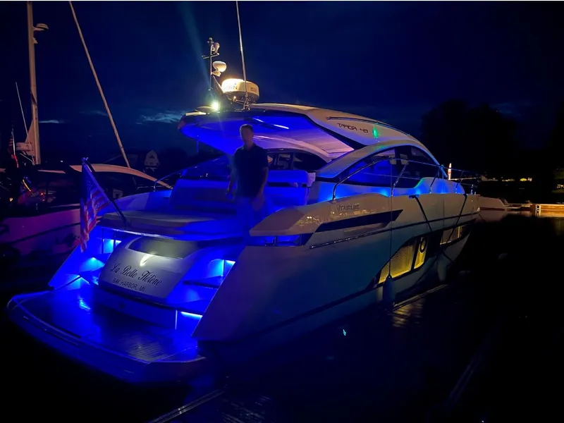 Slide: The Image of 2020 Fairline 45/43 Targa yacht illuminated with blue lights at night. - 17