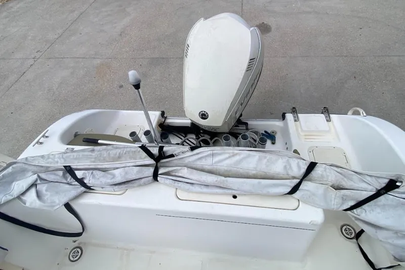 Slide: The Image of 2000 Seafox 21 CC boat with outboard motor and covered equipment on deck. - 11