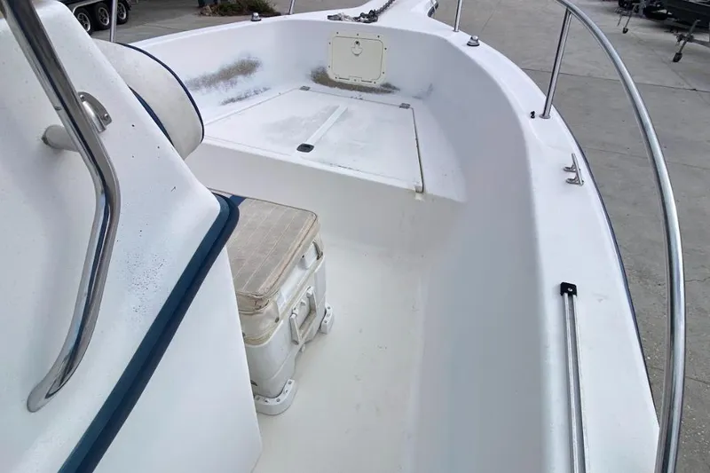 Slide: The Image of 2000 Seafox 21 CC boat interior with seating and storage, featuring stainless steel railings. - 14