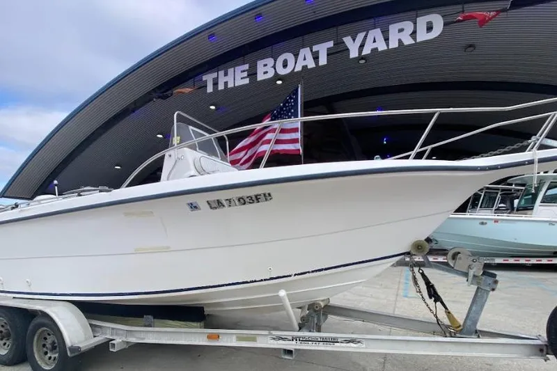 Slide: The Image of 2000 Seafox 21 CC boat on trailer at The Boat Yard, American flag displayed. - 2
