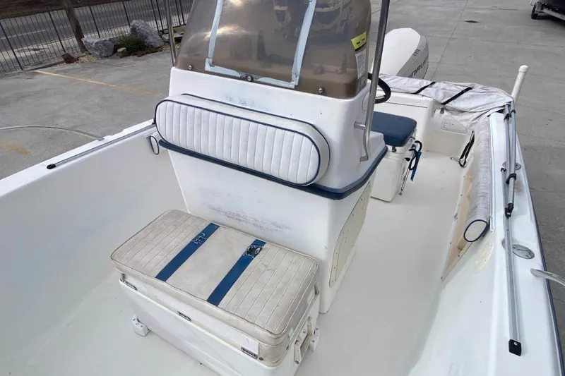 Slide: The Image of 2000 Seafox 21 CC boat interior with seating and console, docked outdoors. - 20