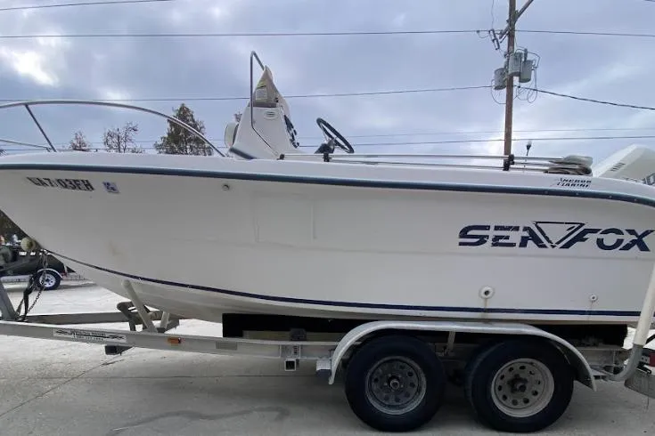 Slide: The Image of 2000 Seafox 21 CC boat on trailer, side view, overcast sky background. - 6