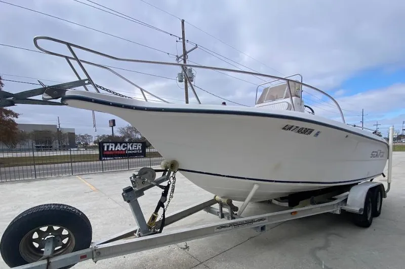 Slide: The Image of 2000 Seafox 21 CC boat on trailer, parked outdoors under cloudy sky. - 7