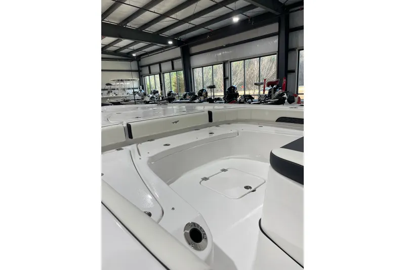 Slide: The Image of 2026 Tidewater 2500 Carolina Bay boat interior in showroom, showcasing spacious deck design. - 6