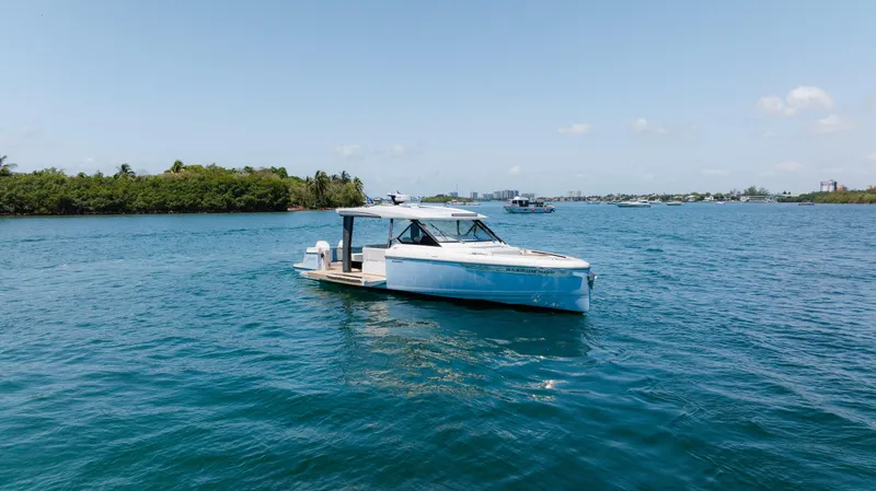 Slide: The Image of 2024 Saxdor 400 GTO boat on open water, rear view, showcasing twin engines. - 48
