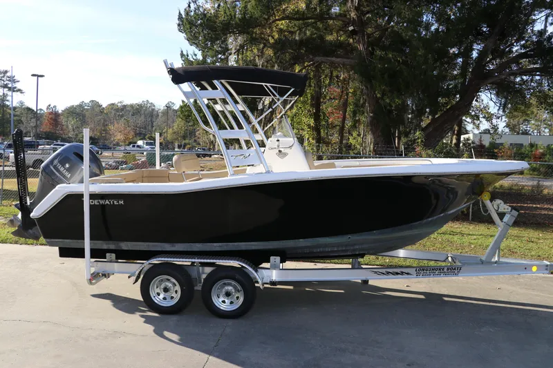 The Image of 2016 Tidewater 220 LXF boat on trailer, black hull, parked outdoors. - 0