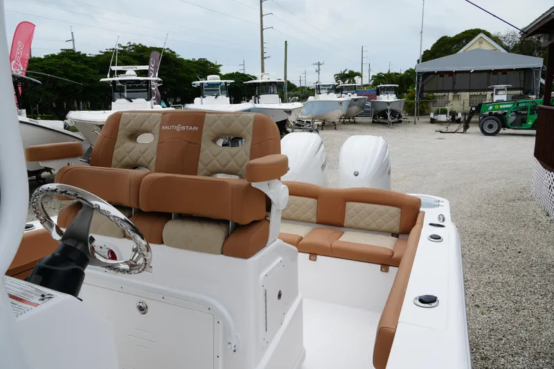 Slide: The Image of 2025 NauticStar 252 Legacy boat with tan seating, displayed outdoors. - 13