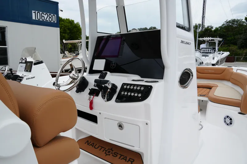 Slide: The Image of 2025 NauticStar 252 Legacy boat interior with steering wheel and control panel. - 19
