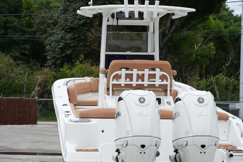 Slide: The Image of 2025 NauticStar 252 Legacy boat with dual Yamaha 150 engines, docked outdoors. - 8