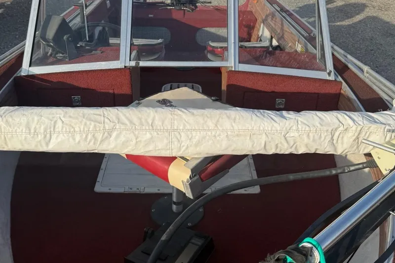 Slide: The Image of 1988 Smoker Craft Magnum 162 boat interior with red carpet and covered equipment. - 5