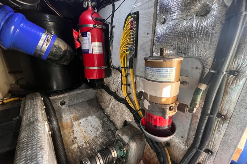 Slide: The Image of Engine room of 2001 Silverton 42C with fire extinguisher and fuel filter system. - 109