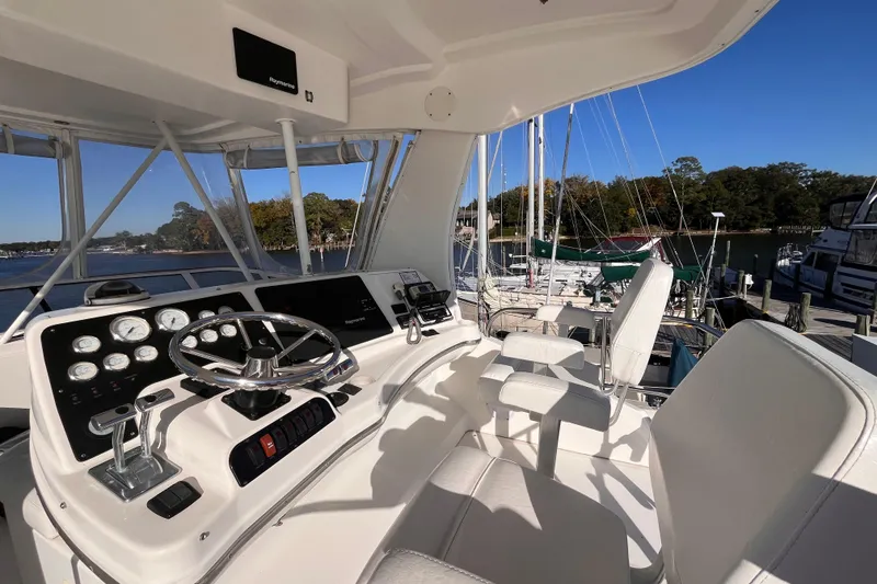 Slide: The Image of 2001 Silverton 42C yacht helm with steering wheel, gauges, and marina view. - 28