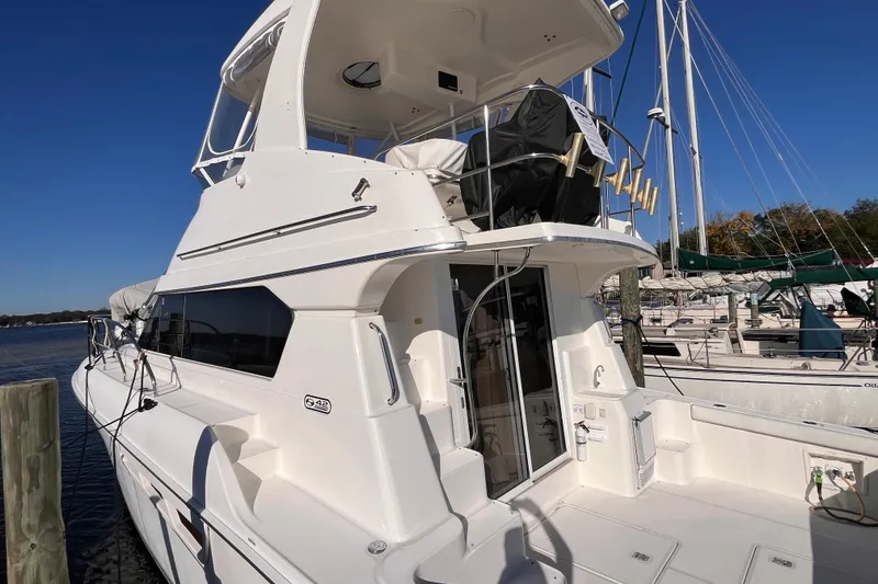 Slide: The Image of 2001 Silverton 42C yacht docked at marina under clear blue sky. - 3