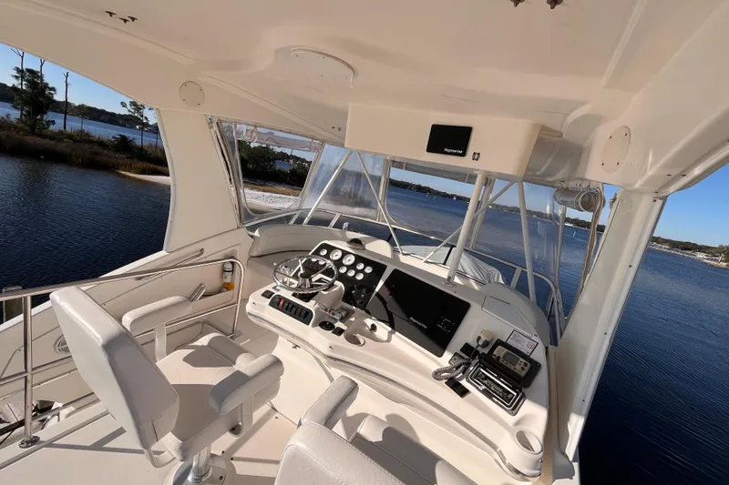 Slide: The Image of 2001 Silverton 42C yacht helm with modern navigation equipment, overlooking serene waters. - 31