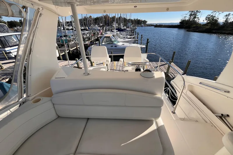 Slide: The Image of 2001 Silverton 42C yacht interior with white seating, docked at a marina. - 32