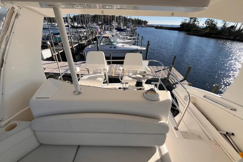 Slide: The Image of 2001 Silverton 42C yacht interior with helm, docked at marina under sunny skies. - 33