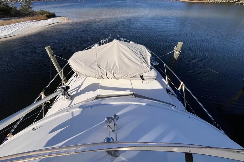 Slide: The Image of 2001 Silverton 42C yacht docked in serene waters, covered equipment on deck. - 34