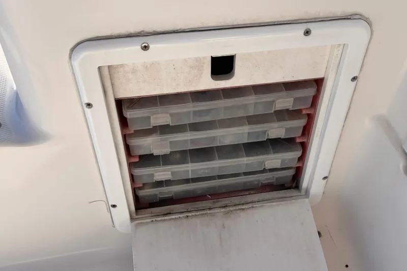 Slide: The Image of Storage compartment with plastic tackle boxes on a 2001 Silverton 42C boat. - 37