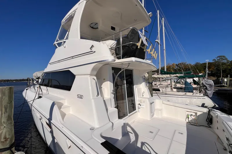 Slide: The Image of 2001 Silverton 42C yacht docked at marina under clear blue sky. - 4