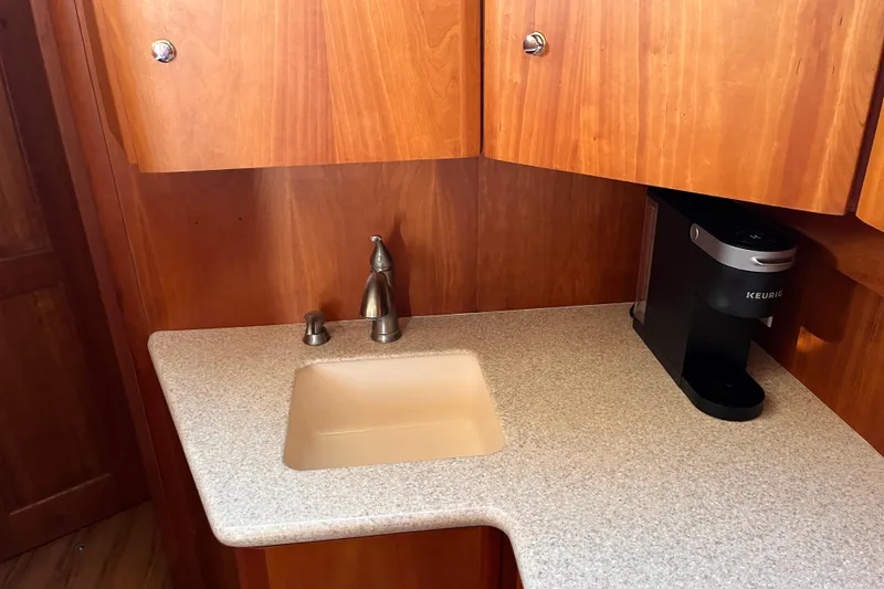 Slide: The Image of 2001 Silverton 42C yacht kitchenette with sink, wooden cabinets, and Keurig coffee maker. - 53