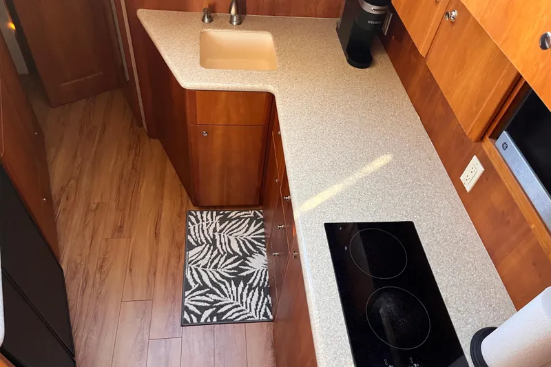 Slide: The Image of 2001 Silverton 42C yacht kitchen with wood cabinets, electric stove, and modern sink. - 56