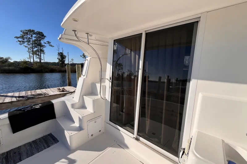 Slide: The Image of 2001 Silverton 42C yacht deck with sliding glass doors and dock view. - 6