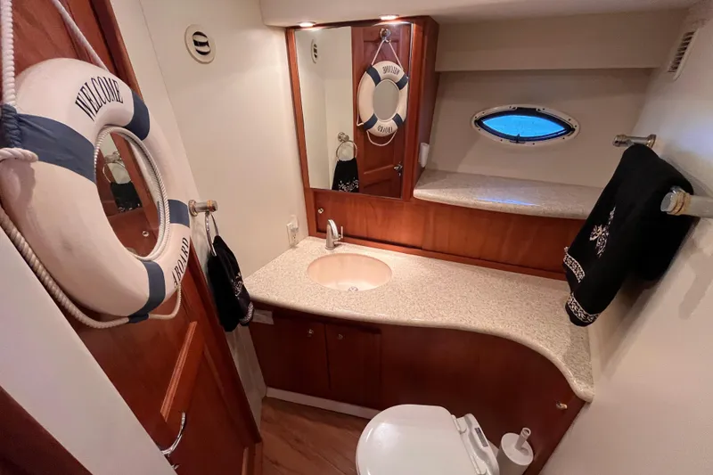 Slide: The Image of Luxurious 2001 Silverton 42C yacht bathroom with elegant wood accents and nautical decor. - 62