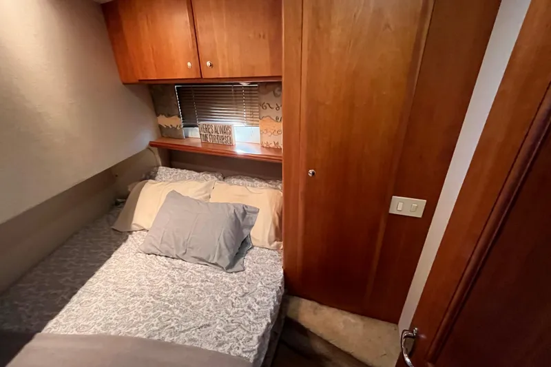 Slide: The Image of Cozy bedroom in 2001 Silverton 42C yacht with wooden cabinets and soft bedding. - 64
