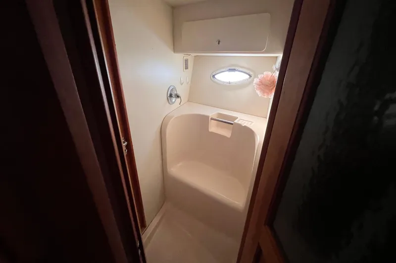 Slide: The Image of Compact bathroom in a 2001 Silverton 42C yacht with oval window and shower seat. - 67