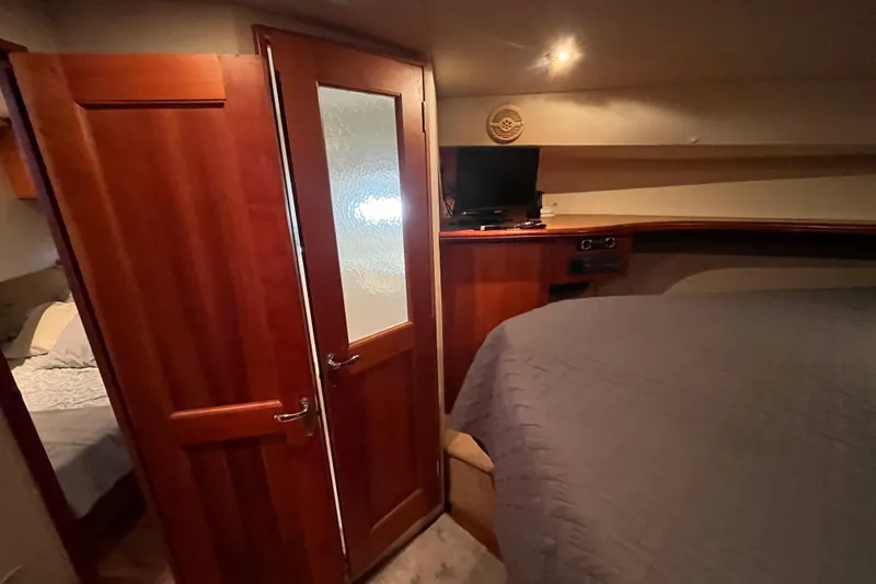 Slide: The Image of 2001 Silverton 42C yacht interior with wooden door, bed, and small TV. - 70