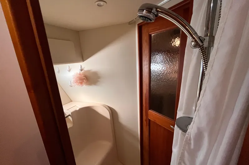 Slide: The Image of Bathroom interior of 2001 Silverton 42C yacht with shower and wooden door. - 76
