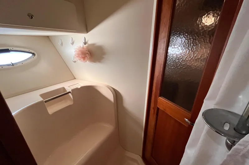 Slide: The Image of Bathroom interior of 2001 Silverton 42C yacht with porthole and wooden door. - 78