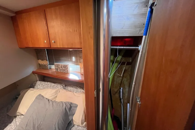 Slide: The Image of Cozy cabin interior of 2001 Silverton 42C with bed, wooden cabinets, and closet space. - 79