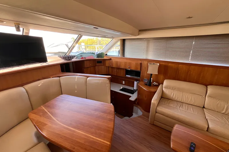 Slide: The Image of Interior of 2001 Silverton 42C yacht with leather seating, wooden table, and modern amenities. - 85