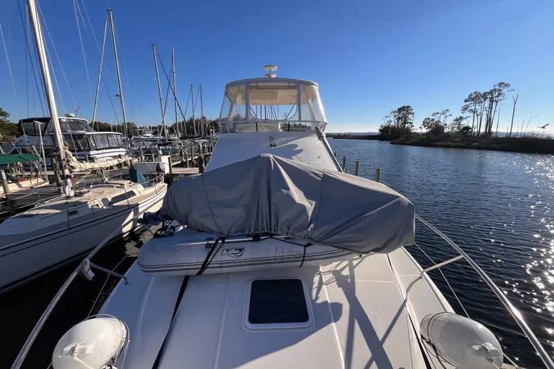 Slide: The Image of 2001 Silverton 42C yacht docked at marina, sunny day, calm water, covered equipment on deck. - 88