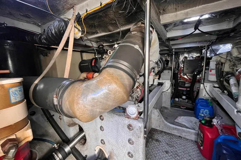 Slide: The Image of Engine room of a 2001 Silverton 42C boat, showcasing mechanical components and wiring. - 93