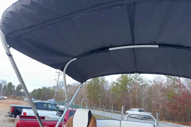 Slide: The Image of 2026 Tahoe Pontoon LTZ 2385 EL Tritoon with canopy, parked outdoors. - 27